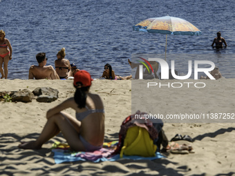 People are relaxing on the beach on the banks of the Dnipro River in Kyiv, Ukraine, on July 06, 2024. Heatwaves of up to 40 degrees Celsius...