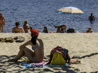 People are relaxing on the beach on the banks of the Dnipro River in Kyiv, Ukraine, on July 06, 2024. Heatwaves of up to 40 degrees Celsius...