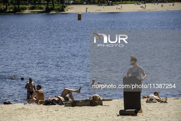 People are relaxing on the beach on the banks of the Dnipro River in Kyiv, Ukraine, on July 06, 2024. Heatwaves of up to 40 degrees Celsius...