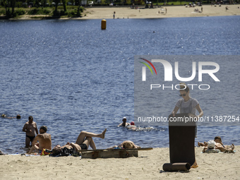 People are relaxing on the beach on the banks of the Dnipro River in Kyiv, Ukraine, on July 06, 2024. Heatwaves of up to 40 degrees Celsius...