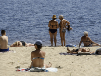 People are relaxing on the beach on the banks of the Dnipro River in Kyiv, Ukraine, on July 06, 2024. Heatwaves of up to 40 degrees Celsius...