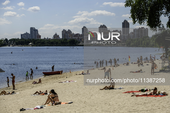 People are relaxing on the beach on the banks of the Dnipro River in Kyiv, Ukraine, on July 06, 2024. Heatwaves of up to 40 degrees Celsius...