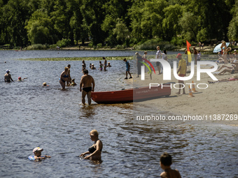 People are relaxing on the beach on the banks of the Dnipro River in Kyiv, Ukraine, on July 06, 2024. Heatwaves of up to 40 degrees Celsius...