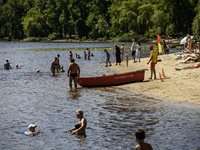 People are relaxing on the beach on the banks of the Dnipro River in Kyiv, Ukraine, on July 06, 2024. Heatwaves of up to 40 degrees Celsius...