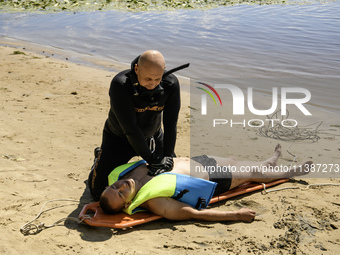 Rescuers are conducting a drowning exercise at a beach on the banks of the Dnipro River in Kyiv, Ukraine, on July 06, 2024 (