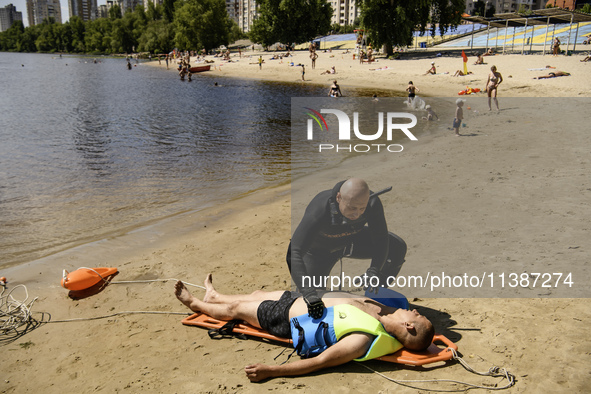 Rescuers are conducting a drowning exercise at a beach on the banks of the Dnipro River in Kyiv, Ukraine, on July 06, 2024 