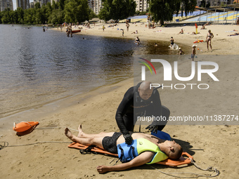 Rescuers are conducting a drowning exercise at a beach on the banks of the Dnipro River in Kyiv, Ukraine, on July 06, 2024 (