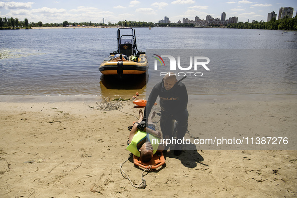 Rescuers are conducting a drowning exercise at a beach on the banks of the Dnipro River in Kyiv, Ukraine, on July 06, 2024 