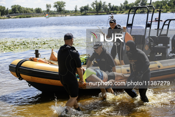 Rescuers are conducting a drowning exercise at a beach on the banks of the Dnipro River in Kyiv, Ukraine, on July 06, 2024 