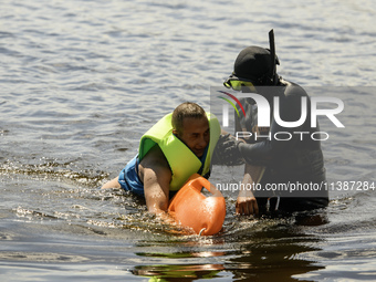 Rescuers are conducting a drowning exercise at a beach on the banks of the Dnipro River in Kyiv, Ukraine, on July 06, 2024 (