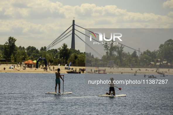 People are relaxing on the beach on the banks of the Dnipro River in Kyiv, Ukraine, on July 06, 2024. Heatwaves of up to 40 degrees Celsius...