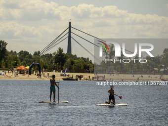 People are relaxing on the beach on the banks of the Dnipro River in Kyiv, Ukraine, on July 06, 2024. Heatwaves of up to 40 degrees Celsius...