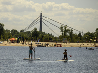 People are relaxing on the beach on the banks of the Dnipro River in Kyiv, Ukraine, on July 06, 2024. Heatwaves of up to 40 degrees Celsius...