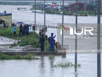 Nepali citizens are watching the rising level of Bagmati River in Kathmandu, Nepal, on July 6, 2024. (