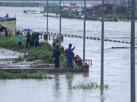 Nepali citizens are watching the rising level of Bagmati River in Kathmandu, Nepal, on July 6, 2024. (