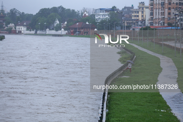 A Nepali citizen is standing on the embankments of the overflowing Bagmati river in Lalitpur, Nepal, on July 6, 2024. With the onset of the...