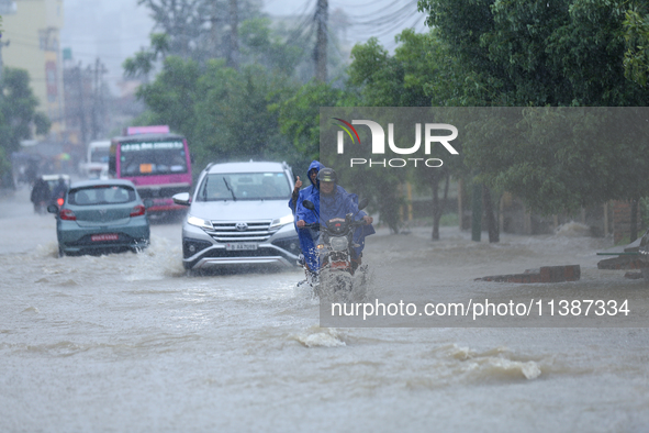 Vehicles are wading through a flooded road in Lalitpur, Nepal, on July 6, 2024. 