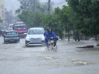 Vehicles are wading through a flooded road in Lalitpur, Nepal, on July 6, 2024. (