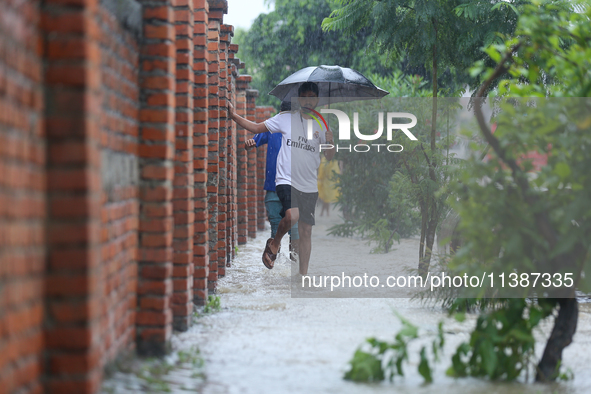 A Nepali man is wading through a river and flooded footways in Lalitpur, Nepal, on July 6, 2024. With the onset of the monsoon in Nepal abou...