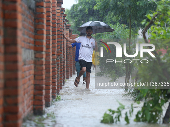 A Nepali man is wading through a river and flooded footways in Lalitpur, Nepal, on July 6, 2024. With the onset of the monsoon in Nepal abou...