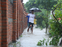 A Nepali man is wading through a river and flooded footways in Lalitpur, Nepal, on July 6, 2024. With the onset of the monsoon in Nepal abou...