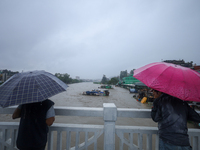 Nepali citizens are watching the rising level of Bagmati River while standing over a bridge in Kathmandu, Nepal, on July 6, 2024. (