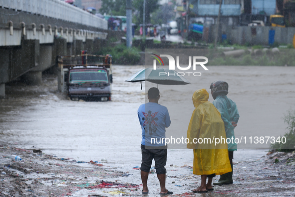 Nepali citizens are watching the rising level of Bagmati River in Kathmandu, Nepal, on July 6, 2024. 