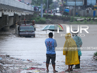 Nepali citizens are watching the rising level of Bagmati River in Kathmandu, Nepal, on July 6, 2024. (