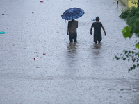 Dissidents in a slum area of Kathmandu are wading through the water in Kathmandu, Nepal, on July 6, 2024. (