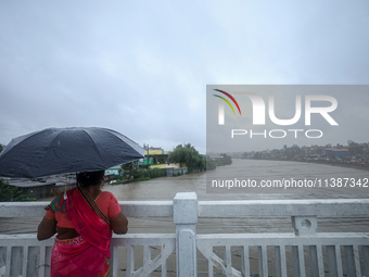 A Nepali woman is watching the rising level of the Bagmati River in Kathmandu, Nepal, on July 6, 2024. (