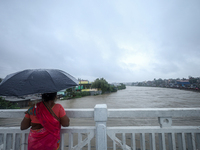 A Nepali woman is watching the rising level of the Bagmati River in Kathmandu, Nepal, on July 6, 2024. (