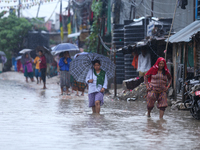 People are wading through the flood in a slum in Kathmandu, Nepal, on July 6, 2024 (