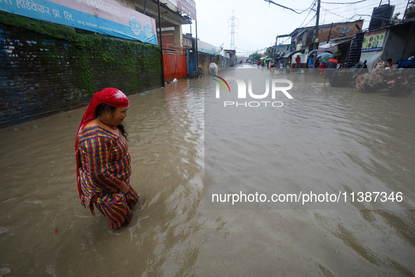 A Nepali woman is wading through the flood in Kathmandu, Nepal, on July 6, 2024. 