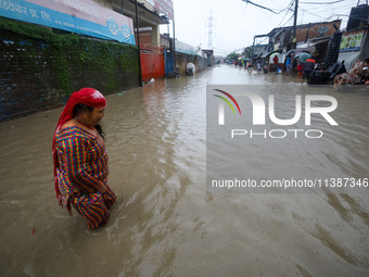 A Nepali woman is wading through the flood in Kathmandu, Nepal, on July 6, 2024. (