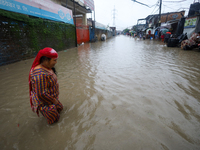 A Nepali woman is wading through the flood in Kathmandu, Nepal, on July 6, 2024. (