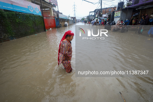 A Nepali woman is wading through the flood in Kathmandu, Nepal, on July 6, 2024. 