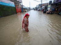 A Nepali woman is wading through the flood in Kathmandu, Nepal, on July 6, 2024. (