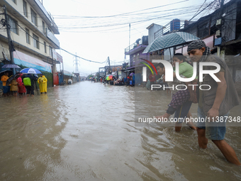 A Nepali man is carrying a member of his family who is under a diagnosis while wading through the flood in Kathmandu, Nepal, on July 6, 2024...