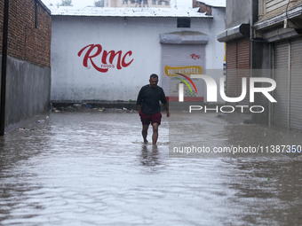 A Nepali man is wading through the flooded water in Nepal on July 6, 2024. (