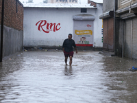 A Nepali man is wading through the flooded water in Nepal on July 6, 2024. (