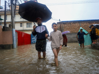 People are wading through the flood in a slum in Kathmandu, Nepal, on July 6, 2024 (