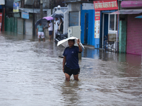 A Nepali man is wading through the flooded water in Nepal on July 6, 2024. (