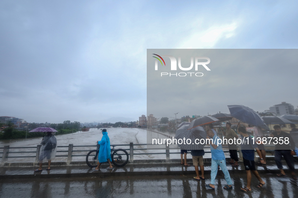 Nepali citizens are watching the rising level of Bagmati River in Kathmandu, Nepal, on July 6, 2024. 