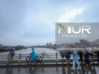 Nepali citizens are watching the rising level of Bagmati River in Kathmandu, Nepal, on July 6, 2024. (