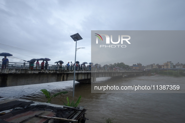 Nepali citizens are watching the rising level of Bagmati River in Kathmandu, Nepal, on July 6, 2024. 