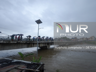 Nepali citizens are watching the rising level of Bagmati River in Kathmandu, Nepal, on July 6, 2024. (