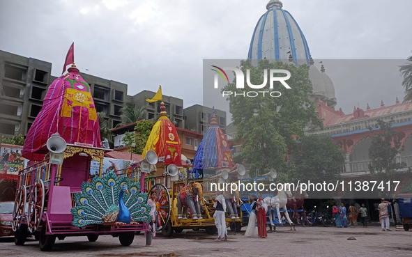 Devotees are standing near the decorated Rath (Chariot) at ISKCON Temple premises on the eve of the Rath Yatra in Siliguri, India, on July 6...