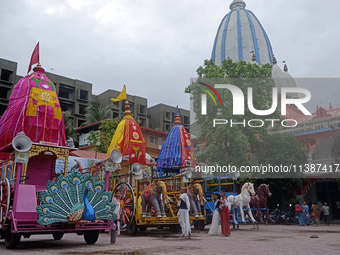 Devotees are standing near the decorated Rath (Chariot) at ISKCON Temple premises on the eve of the Rath Yatra in Siliguri, India, on July 6...