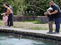 People are fishing for rainbow trout at a pond in Stouffville, Ontario, Canada, on May 12, 2024. (