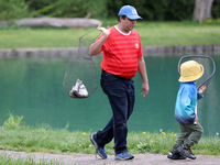 A man is holding a basket with freshly caught rainbow trout at a pond in Stouffville, Ontario, Canada, on May 12, 2024. (